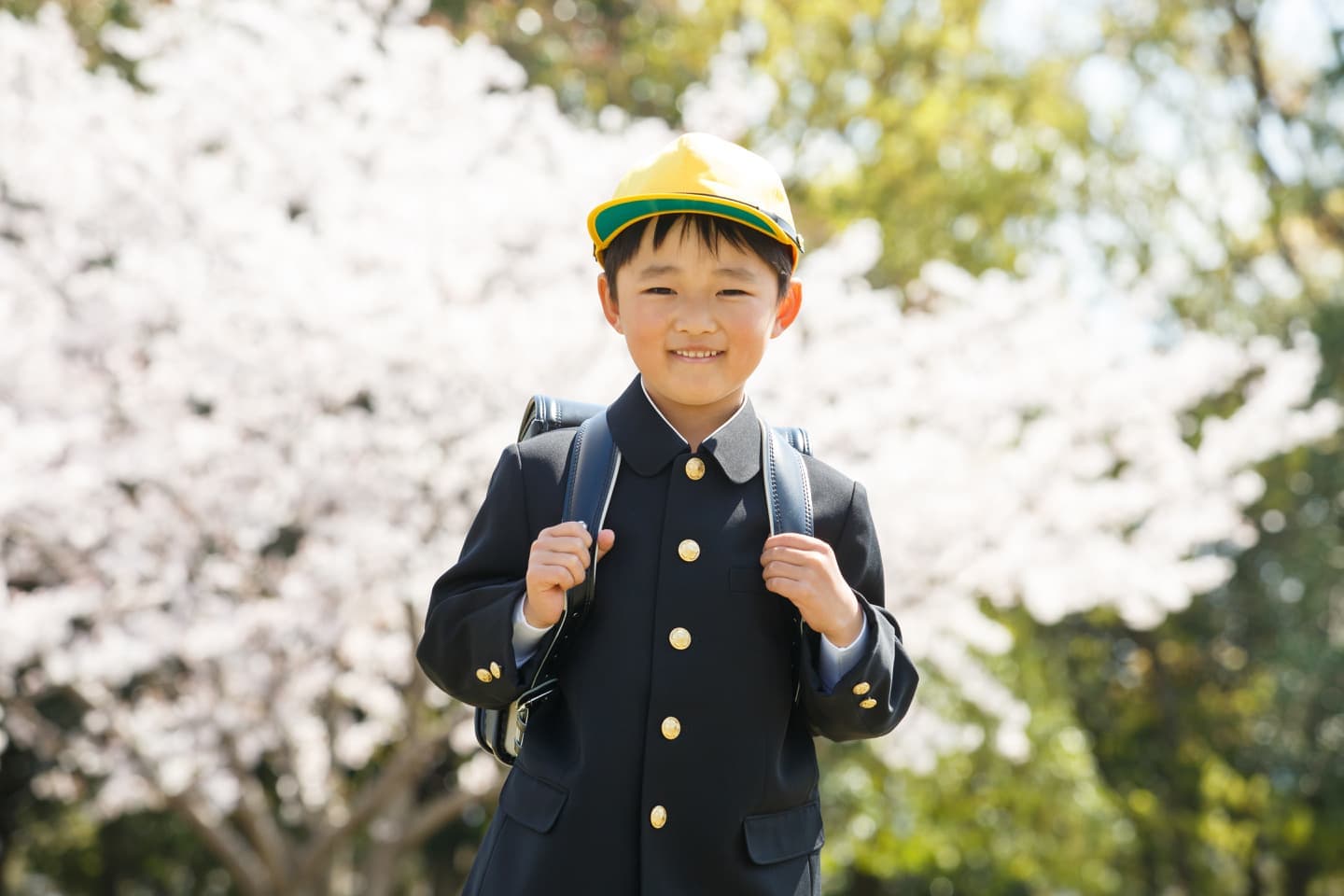 桜の前でランドセルを背負う男の子
